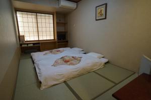 Ένα ή περισσότερα κρεβάτια σε δωμάτιο στο Annex Katsutaro Ryokan