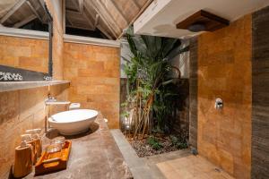 a bathroom with a toilet and a plant at D'Gume Villas Lembongan in Nusa Lembongan +61 photos