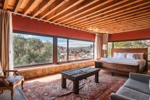 ein Schlafzimmer mit einem Bett und einem großen Fenster in der Unterkunft Casa del Rector Hotel Boutique in Guanajuato + 42 Fotos