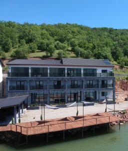 a large building on the water with a dock at Pensiunea EUPHORIA in Sviniţa