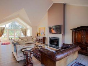 a living room with a leather couch and a fireplace at Belvedere Boutiqe Hotel in Windhoek