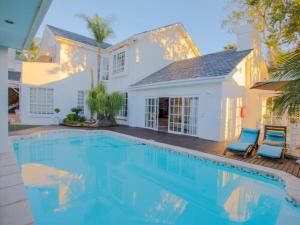 a swimming pool in front of a white house at Belvedere Boutiqe Hotel in Windhoek