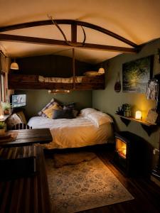 a bedroom with a large bed and a fireplace at Mountbatten Shepherds hut & Buckhurst Shepherds hut in Ashford
