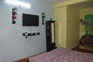 a bedroom with a flat screen tv on the wall at The Prem Vatika Homestay Maihar in Maihar