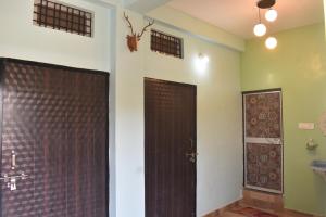 a bathroom with a shower and a wooden door at The Prem Vatika Homestay Maihar in Maihar +40 photos