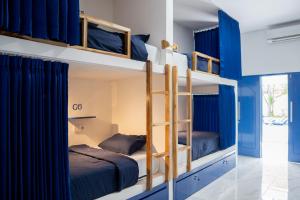 two bunk beds in a room with blue walls at El Mojo Hostel in Selong Belanak