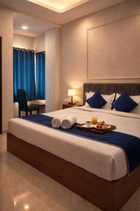 a hotel room with a bed with a tray of food on it at Accuotel Inn RG Grand in Kanāria