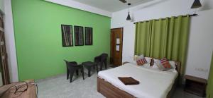 a bedroom with a bed and a green wall at Hottel! Basera in Bhubaneshwar