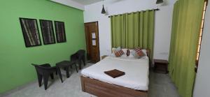 a bedroom with a bed and a green curtain at Hottel! Basera in Bhubaneshwar +2 photos