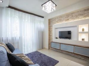 a living room with a couch and a tv at Urban Chic - One Bedroom Apartment -Luxury Warsaw Stays - Grzybowska 5 in Warsaw