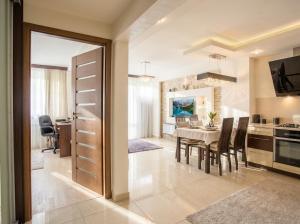 a kitchen and dining room with a table and chairs at Urban Chic - One Bedroom Apartment -Luxury Warsaw Stays - Grzybowska 5 in Warsaw +6 photos