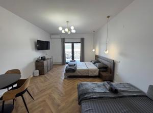 a room with two beds and a table and a couch at Pensiunea EUPHORIA in Sviniţa