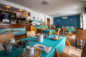 ein Esszimmer mit blauen Tischen und Stühlen in der Unterkunft Hotel Eliani in Grado