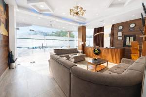 ein Wohnzimmer mit einem großen Sofa und einem Tisch in der Unterkunft Hotel HTC , Thimphu in Thimphu + 20 Fotos