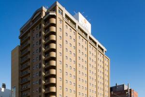 un edificio alto en una ciudad con un cielo azul en Premier Hotel -CABIN- Asahikawa en Asahikawa