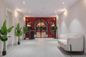 a living room with a white couch and a red door at Hotel Lohara Inn in Chandrapur