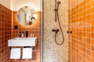 a bathroom with a shower with a sink and a mirror at Hôtel La Garrigue & Bar Le Perchoir in Venasque