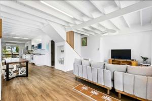 a living room with a couch and a tv at Pet friendly100m to Beach and Cafe by Custom Bnb Hosting in Urangan