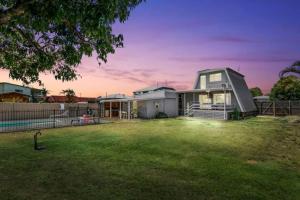 a home with a large yard with a house at Pet friendly100m to Beach and Cafe by Custom Bnb Hosting in Urangan