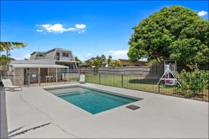a swimming pool in front of a house at Pet friendly100m to Beach and Cafe by Custom Bnb Hosting in Urangan
