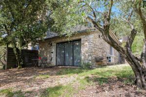 a brick house with a large black garage at Gite Du Mouredon in Vallon-Pont-dʼArc