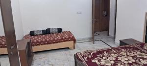 two beds sitting in a room with a door at Sewa Kunj in Mussoorie