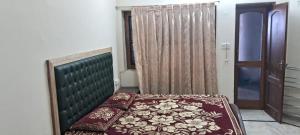 a bedroom with a bed with a green head board at Sewa Kunj in Mussoorie +3 photos