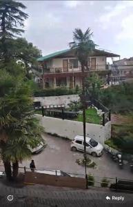 a car parked in a parking lot in front of a house at Sewa Kunj in Mussoorie