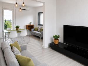 a living room with a couch and a flat screen tv at VILLA PARADISE SILVIA in Sant Pere de Ribes