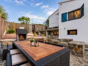 a backyard with a wooden table and a fireplace at VILLA PARADISE SILVIA in Sant Pere de Ribes