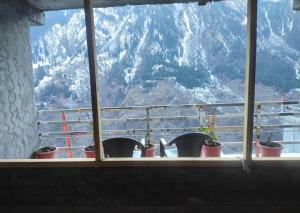 a window with potted plants and a view of a mountain at lake view resort kafnoo in Yangpa