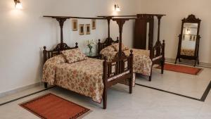 a bedroom with two beds and a mirror at AM Hotel Kollection- Maangarh, Ratlam in Sailāna