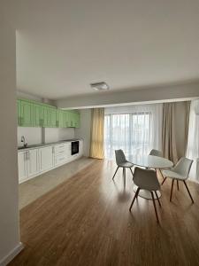 a living room with a table and chairs and a kitchen at Hotel Class in Oradea