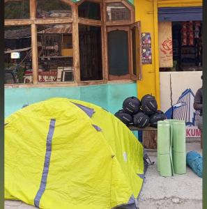 a yellow tent sitting in front of a building at lake view resort kafnoo in Yangpa