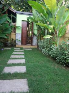 a garden with a pathway leading to a house at Green Cottage Lembongan by ABM in Nusa Lembongan