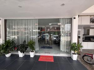 a store front with potted plants in front of a window at Collection O Near Sunway Karnival Mall Formerly Rest Haven in Bukit Mertajam