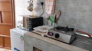 a kitchen counter with a stove on top of a refrigerator at Unique place Studio Thika in Thika +21 photos