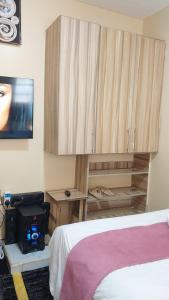 a bedroom with a bed and a cabinet and a tv at Unique place Studio Thika in Thika