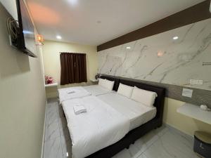 a bedroom with a large bed with white sheets at Collection O Near Sunway Karnival Mall Formerly Rest Haven in Bukit Mertajam +23 photos