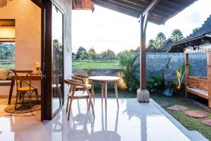 a patio with a table and chairs and a view at Bagus Bandem Villa in Ubud