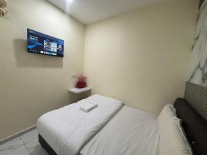 a room with a bed with a tv on the wall at Collection O Near Sunway Karnival Mall Formerly Rest Haven in Bukit Mertajam