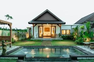 a villa with a pool in front of a house at Bagus Bandem Villa in Ubud
