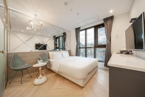 a hotel room with a white bed and a sink at Hotel Lassa in Seoul