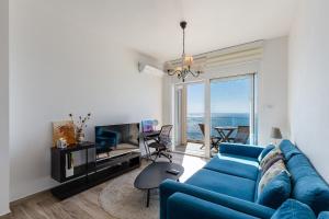 a living room with a blue couch and a television at Your Home Montenegro in Dobra Voda