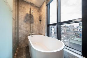 a bath tub in a bathroom with a window at Hotel Lassa in Seoul +14 photos