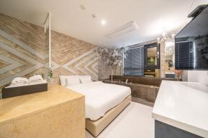 a bedroom with a bed and a bath room at Hotel Lassa in Seoul