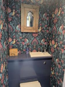 a bathroom with a sink and a mirror at Historic maisonette cottage in Cuckfield
