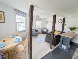 a living room with a table and a fireplace at Historic maisonette cottage in Cuckfield