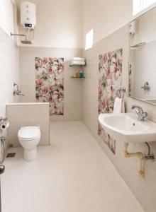 a bathroom with a toilet and a sink at AM Hotel Kollection- Maangarh, Ratlam in Sailāna +12 photos