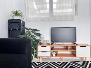 a living room with a tv and a black chair at SleepOver BDI2 in Wonosobo